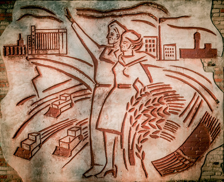 Dobrush, Belarus - February 27, 2016: Old abandoned Soviet mural depicting workers and farmers. approximately 1970 years. Cropped partのeditorial素材