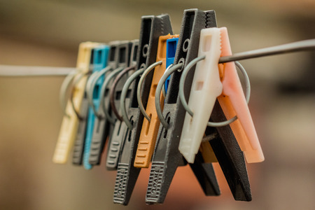 Ten plastic linen clothespins close-up hanging on the clothesline wire