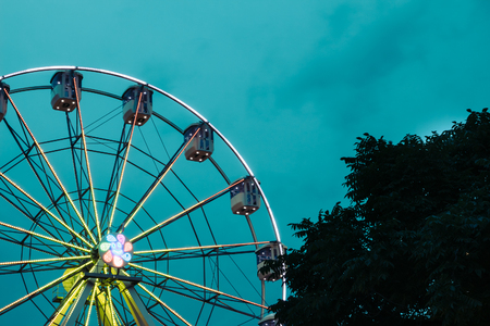 Ferris wheel at an amusement park with backlit against the skyの写真素材