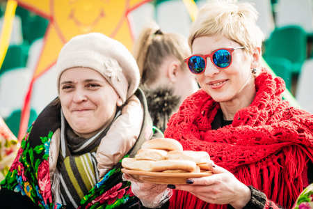 Gomel, Belarus - March 12, 2016: Two women offer guests a feast of pancakes on Shrovetide in Belarusのeditorial素材