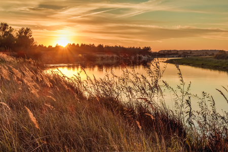 Golden beautiful sunset on the horizon over the riverの写真素材