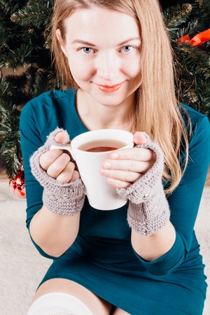 Beautiful girl in a green dress with a cup in his hands