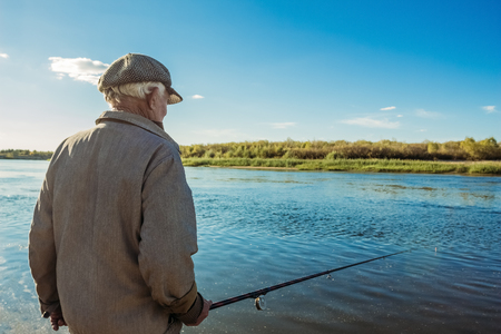 An elderly fisherman on a fishing tripの写真素材