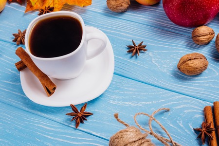 White cup of coffee and a saucer on a blue wooden surfaceの写真素材