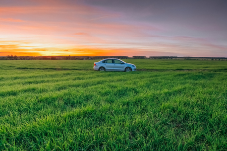 Volkswagen Polo Vento in against the sunset in a summer rural fiのeditorial素材