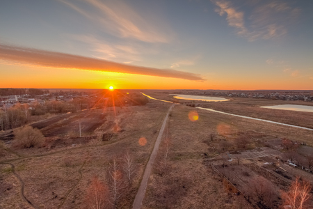 Sun at dawn on the horizon above the villageの写真素材