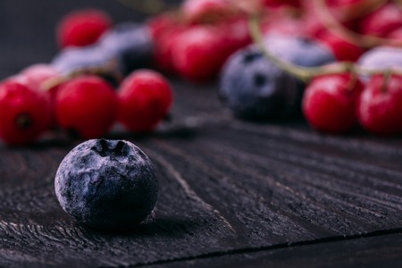 Frozen blueberry berry close-up on the background of other berriの写真素材