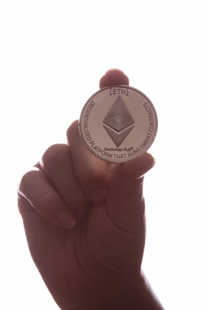 Hand with coin cryptocurrency Ethereumの写真素材
