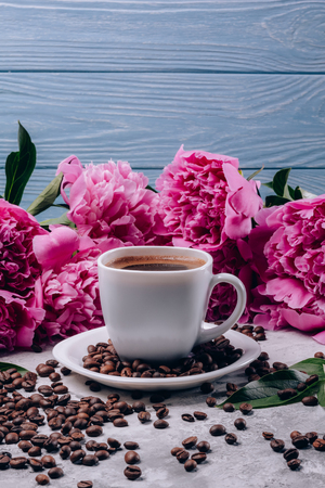 Flowers of peonies with pink buds and coffee in a cupの写真素材