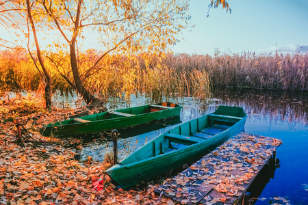 Sunset on the river with boats off the coast covered with fallenの写真素材