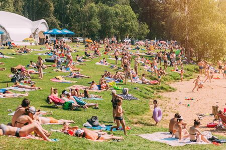 Mozhaisk, Russia - June 28, 2018: Many people relax on a grassy beach near the reservoir on a summer dayのeditorial素材