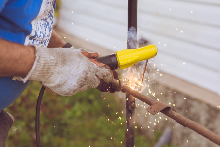 The work of the welding machine in the hands close-up with fire and sparks