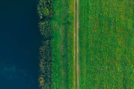 Aerial view - a country road in a green summer field near the lake. Backgroundの写真素材