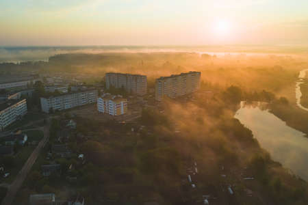 The sleeping area of a small town in the fog of a summer morning. View from aboveの写真素材