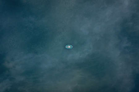Lake dark blue water fisherman in boats lonely fishing relax on the water. View from aboveの写真素材