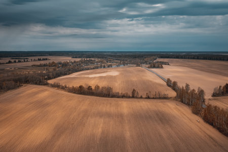 Autumn agricultural fields under dramatic sky with cloudsの写真素材