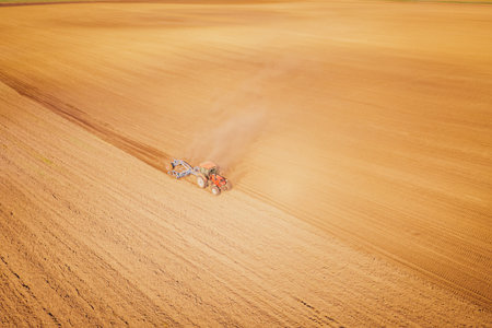 Aerial View of Farming Tractor Plowing Field for Agricultural Harvest Preparationの写真素材