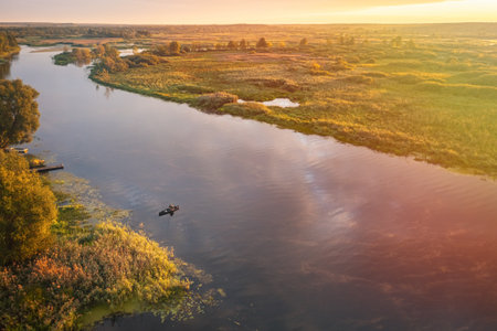 A serene river landscape at sunset, featuring lush greenery and stunning water reflectionsの写真素材