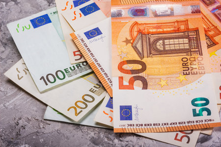 A collection of various Euro currency notes displayed prominently against a stylish gray backgroundの写真素材
