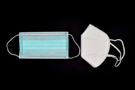 Disposable KN-95 mask vs thin surgical mask. COVID-19 prevention. H1N1, H5N1 safety measures. Isolated on black background.の写真素材