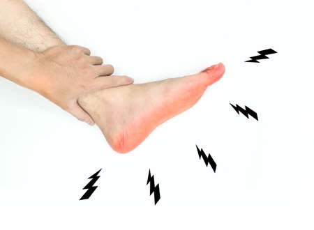 Tingling and burning sensation in foot of Asian young man with diabetes. Sensory neuropathy problems. Foot nerves problems. Isolated on white.の写真素材