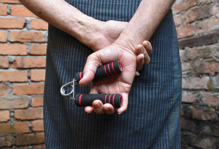 Southeast asian, Myanmar old man gripping hand exercise gripper.の写真素材