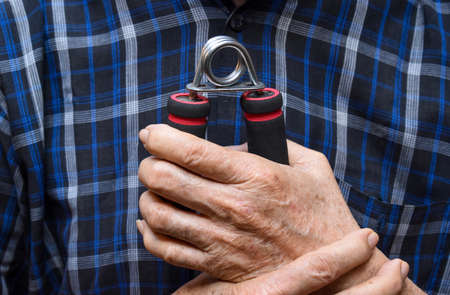 Southeast asian, Myanmar old man gripping hand exercise gripper.の写真素材