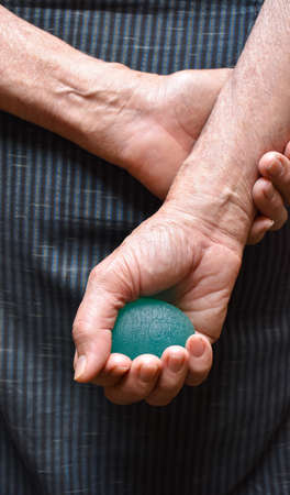 Southeast asian, Myanmar old man gripping hand exercise elastic ball.の写真素材