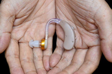 Electronic hearing aid device in the ear of Asian old man with total deafness.の写真素材