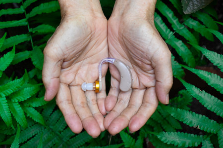 Electronic hearing aid device in the ear of Asian old man with total deafness.の写真素材