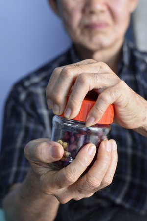 Asian Chinese man screwing the cap of glass bottle. Concept of hand muscle strength and power.の写真素材