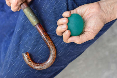 Southeast asian, Chinese old man gripping hand exercise elastic ball.