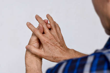Inflammation of Asian old man middle finger and hand. Concept of arthritis and finger problem.の写真素材