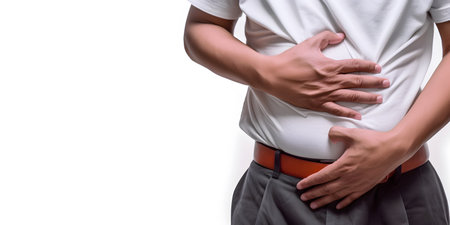Asian man suffering from upper abdominal pain. It can be caused by stomach ache, enteritis, colitis, appendicitis, hepatitis, pancreatitis, food poisoning, etc.の素材