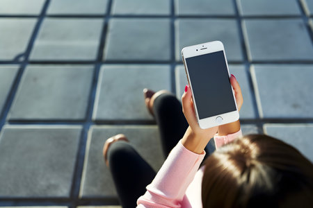 Woman holding her smartphone. Mockup phone screen.の素材