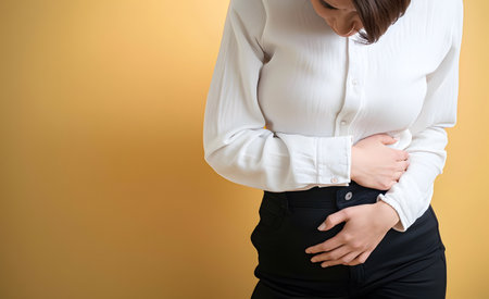 Woman suffering from abdominal pain. It can be caused by stomach ache, enteritis, colitis, appendicitis, hepatitis, pancreatitis, food poisoning, menstruation, pelvic inflammatory disease, etc.の素材