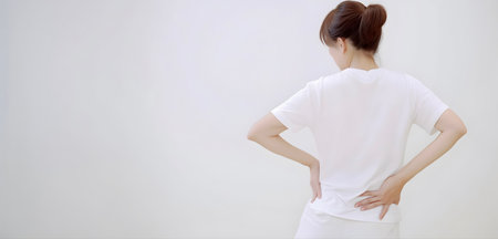 Asian young woman suffering from low back and loin pain. It can be caused by mechanical or pathological process.の素材