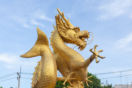 Big golden dragon statue in sunny dayの写真素材