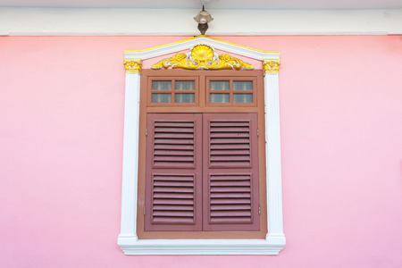 A beautiful window on pink wall in Sino Portuguese style at Soi Rommanee, Phuket, Thailandの写真素材