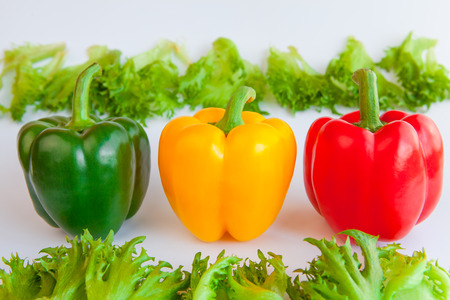Fresh ripe vegetables three sweet Green, Yellow, Red  Peppers isolated and leaves of frillis on white background. Bell peppers.の写真素材
