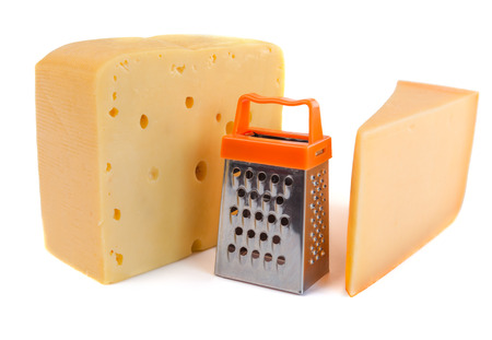 Pieces of huge cheeses of different tastes and tiny metal grate for preparing grated cheese isolated on whiteの写真素材