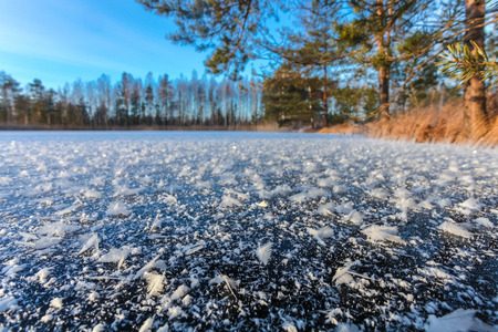 Snowflakes  on surface of lake covered by ice on winter morning. Close upの写真素材