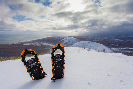 Professional snowshoes in the snow on the winter mountains background. Snowshoeing.の写真素材