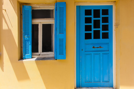 Rethymno, Island Crete, Greece, - June 23, 2016: Traditional Greek house with window with blue shutters and wood doorのeditorial素材