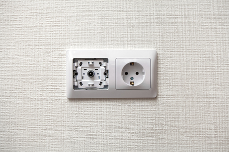 An electrical socket and TV outlet on wall in the roomの写真素材