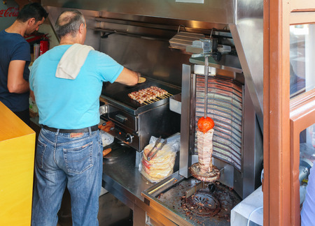 Rethymno, Island Crete, Greece, - June 23, 2016: Traditional Greek tiny street cafe where two men are cooking traditional and national greek fast food  - tasty gyros, souvlaki and meatballs for local citizens and tourits.のeditorial素材