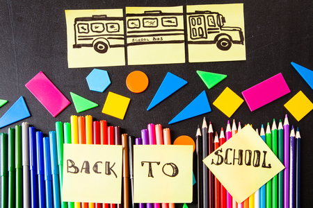 Back to school background with a lot of colorful felt-tip pens and colorful pencils, titles Back to...