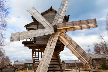 Old wooden windmill in Russia is located in the village with wooden housesの写真素材