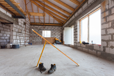 Ladder, parts of scaffolding and construction material on the floor during on the remodeling, renovation, extension, restoration, reconstruction and constructionの写真素材
