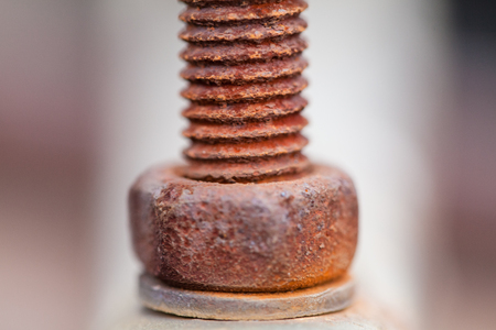 Close-up image of old rusty screw and bolt on steel surface with blurred backgroundの写真素材